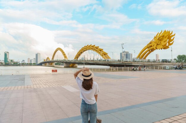 Vrouw Reiziger op bezoek in de stad Da Nang Toerist die het uitzicht op de rivier bezichtigt met Dragon Bridge Landmark en populair voor toeristische attractie Vietnam en Zuidoost-Azië reisconcept