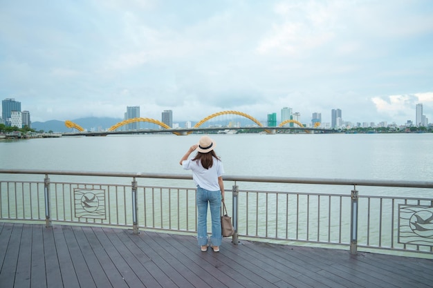 Vrouw Reiziger op bezoek in de stad Da Nang Toerist die het uitzicht op de rivier bezichtigt met Dragon Bridge Landmark en populair voor toeristische attractie Vietnam en Zuidoost-Azië reisconcept