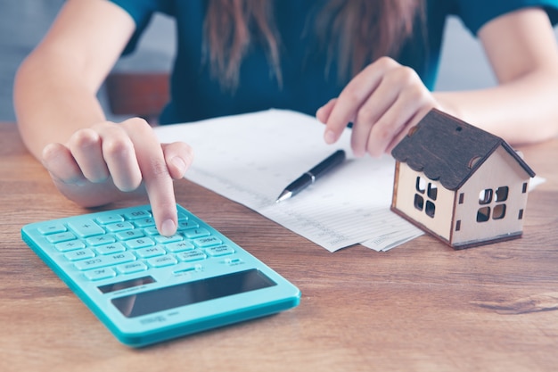 Vrouw rekent op rekenmachine voor het huis