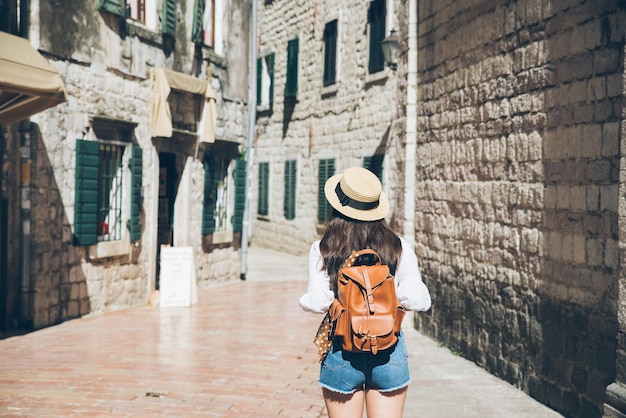 Vrouw rent door de stad Kotor op zonnige dag