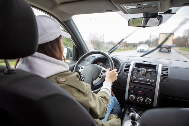 Vrouw rijdende auto bij regenachtig weer vanuit de kopieerruimte van het dashboard