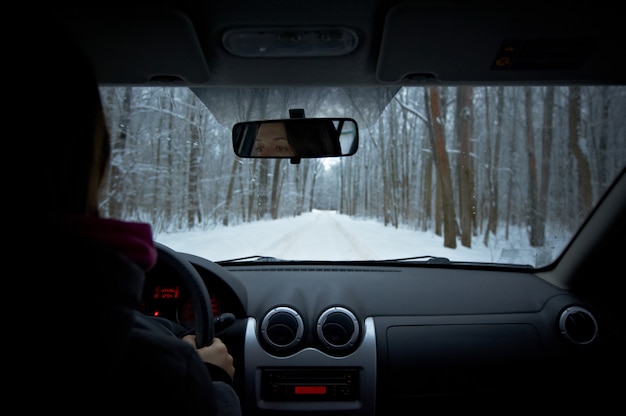 Vrouw rijdt een auto op een winterse dag