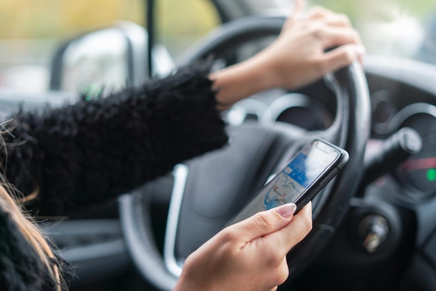 vrouw rijdt en gebruikt kaart op smartphone