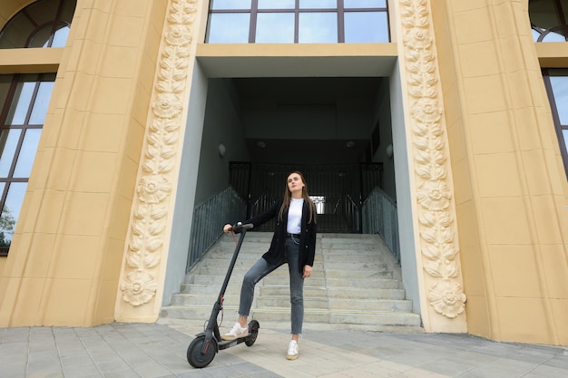 Vrouw rijdt op een elektrische scooter in de stad Milieuvriendelijk vervoer