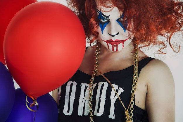 Vrouw, roodharige clown met een ballon, Halloween