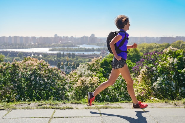 Vrouw runner run pendelt om te werken met rugzak, stad ochtend lopen pendelen en fitness concept, Kiev, Oekraïne
