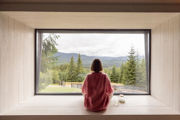 Vrouw rust in huis bij bergen