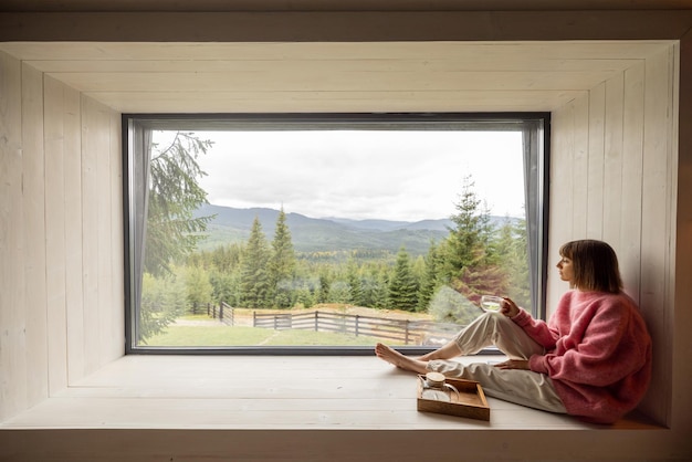 Vrouw rust in huis met schilderachtig uitzicht op bergen