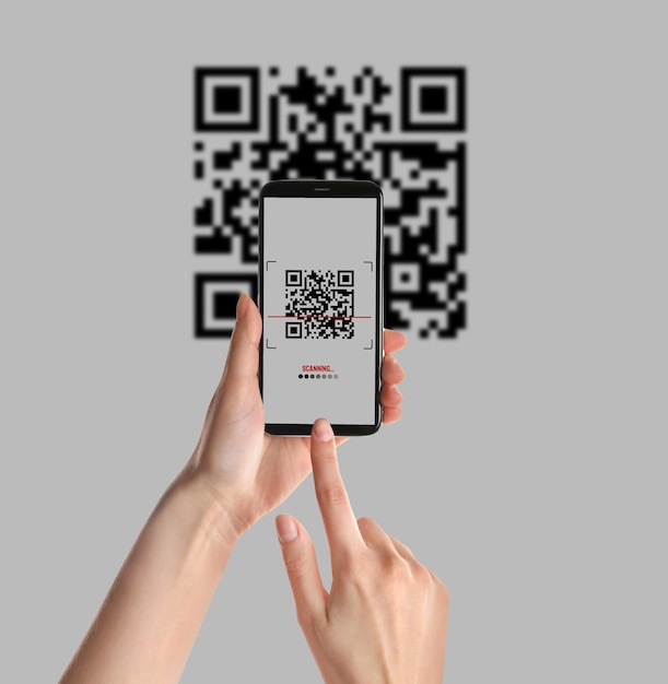 Vrouw scannen QR-code met smartphone op lichte achtergrond close-up