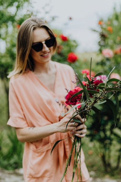 Vrouw schikt bloemen in een tuin