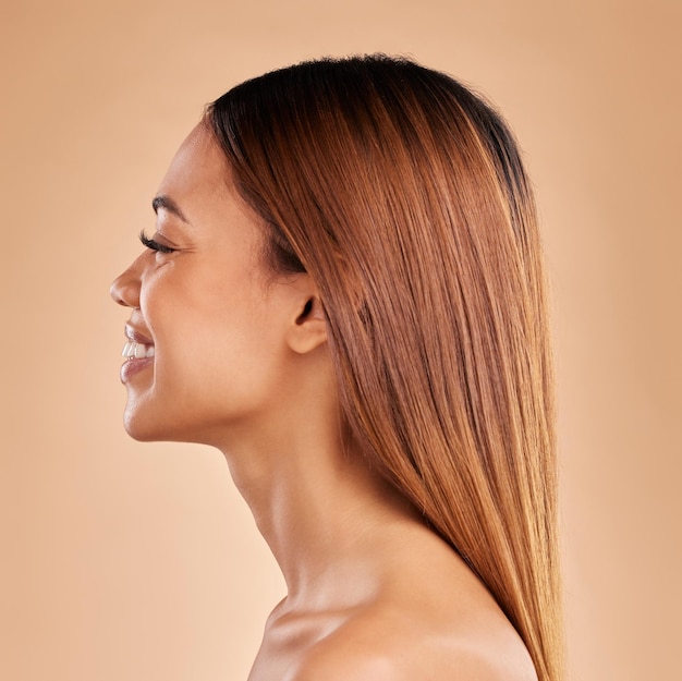 Foto vrouw schoonheid en haarverzorging profiel met een glimlach voor groei en glans shampoo op een bruine achtergrond esthetische vrouw gelukkig in studio voor natuurlijke keratine behandeling en wellness met kleur en textuur