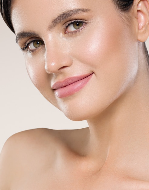 Vrouw schoonheid gezicht gezonde schone huid natuurlijke make-up schoonheid ogen vrouwelijke jonge model Beige achtergrond.
