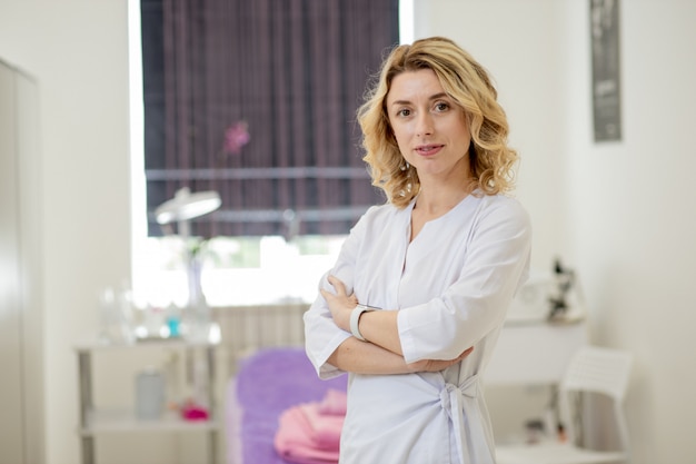 Vrouw schoonheidsspecialist arts aan het werk in kuuroordcentrum. Portret van een jonge vrouwelijke professionele schoonheidsspecialiste. Vrouwelijke werknemer in cosmetologie kabinet of schoonheidssalon. Beroep in de gezondheidszorg, medische carrière