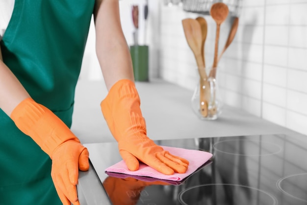 Vrouw schoonmaak kachel met rag