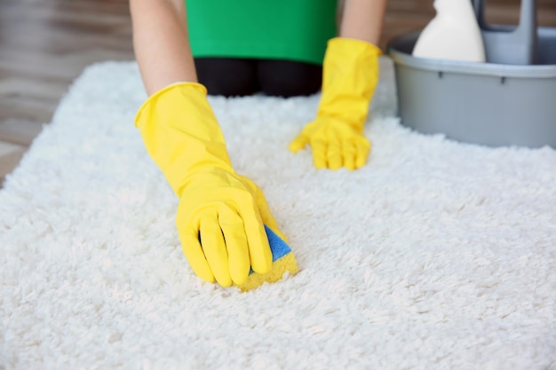 Vrouw schoonmaak tapijt in de kamer