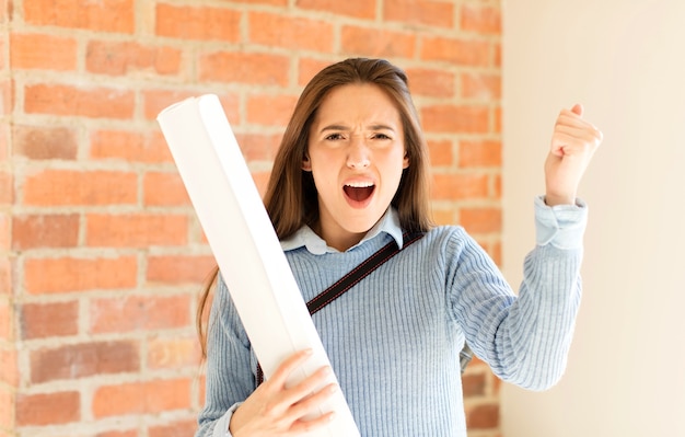 Vrouw schreeuwt agressief met een boze uitdrukking of met gebalde vuisten om succes te vieren