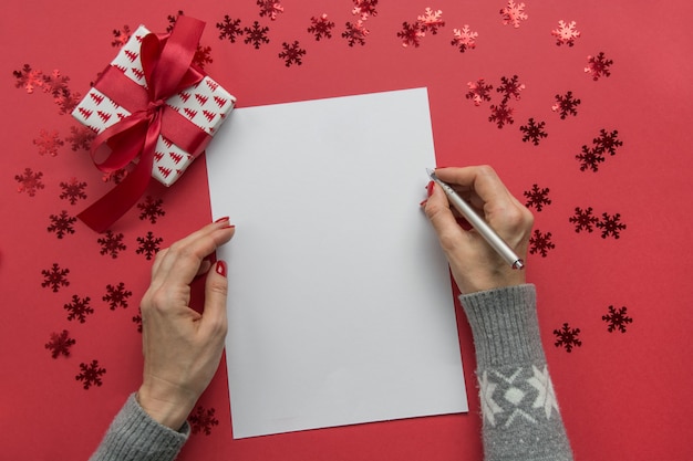 Vrouw schrijft doelen, checklist, plannen en dromen voor het nieuwe jaar. wensenlijst voor kerstmis. te doen lijst