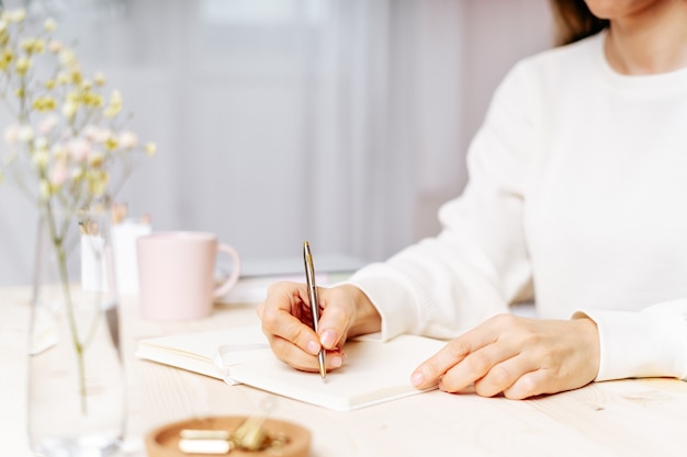 Vrouw schrijft in notitieblok