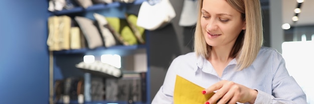 Vrouw schrijft met pen in notitieboekje en bladert door catalogus met stoffen die gordijnen naaien