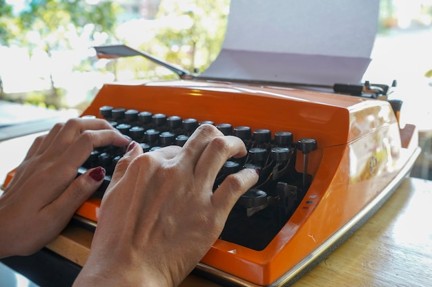 Vrouw schrijft op een oude typemachine.