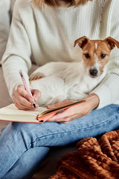 Foto vrouw schrijft thuis notities in notitieboekje