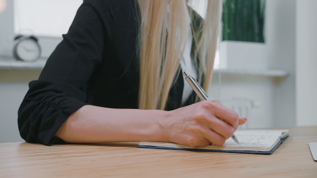 Vrouw schrijven met pen in Kladblok