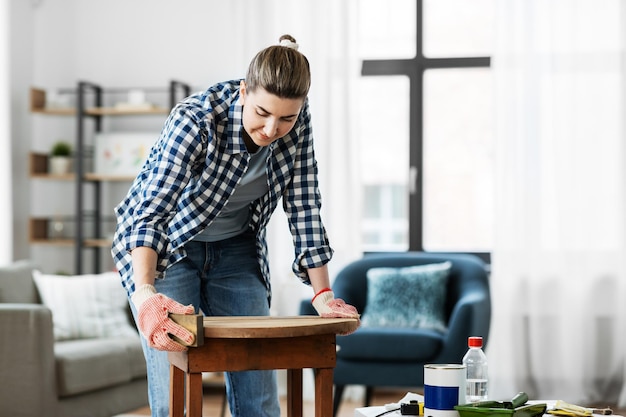vrouw schuurde oude ronde houten tafel met spons