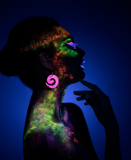 Vrouw sensuele poseren in fluorescerende verf make-up
