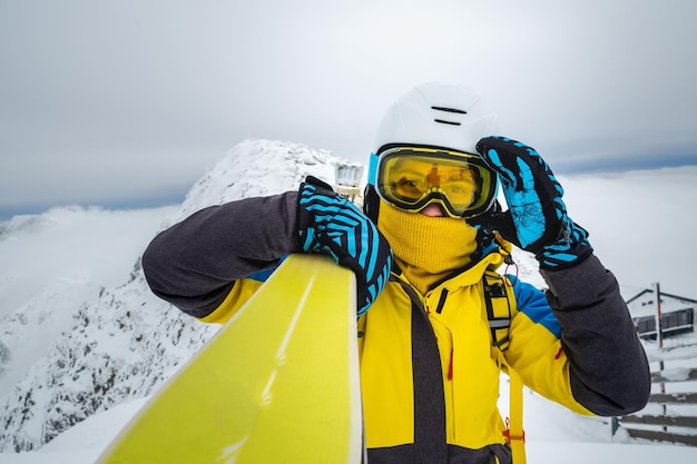 Vrouw skiër poseren op de top van besneeuwde berg kopie ruimte