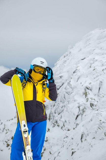 Vrouw skiër poseren op de top van besneeuwde berg