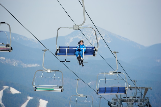 Vrouw skiër rijden tot aan de top van de berg