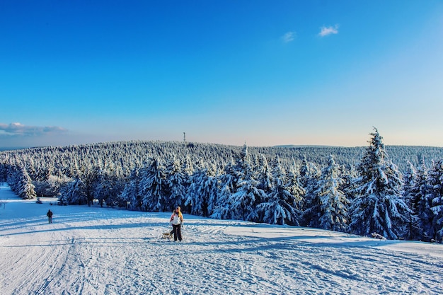 Vrouw skiet op het veld tegen de blauwe hemel in de winter