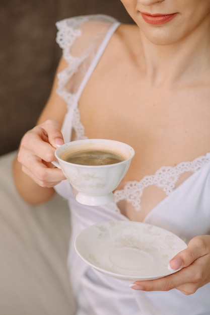 Vrouw slaapkamer bed koffie drinken