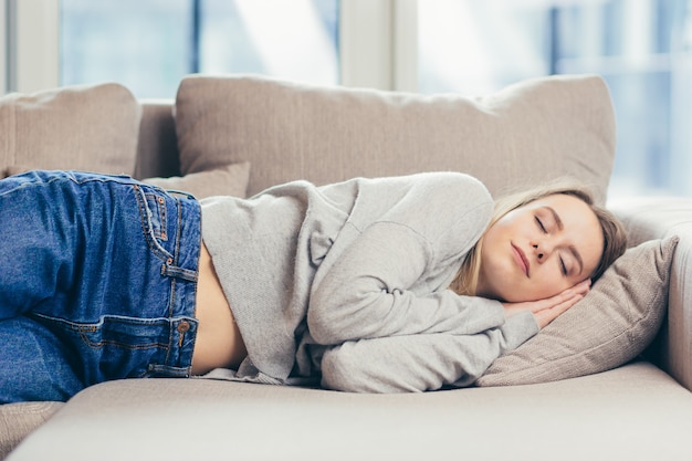 vrouw slaapt thuis op de bank uit na een zware dag