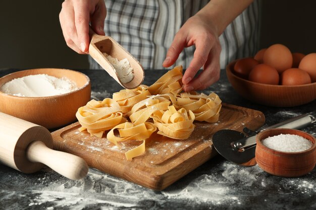 Vrouw smakelijke pasta koken op donkere tafel