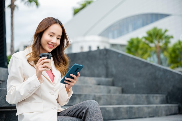 Vrouw sms'en en koffie drinken buiten