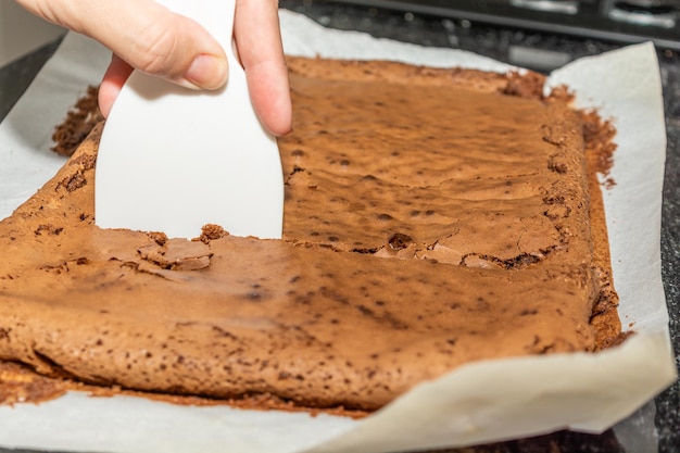 Vrouw snijden chocolade brownie zelfgemaakte gourmet
