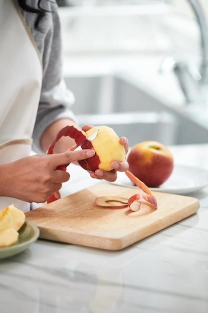 Vrouw snijdt schil uit appel