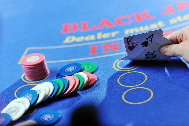 vrouw speelt black jack-kaartspel in casino op blauwe tafel