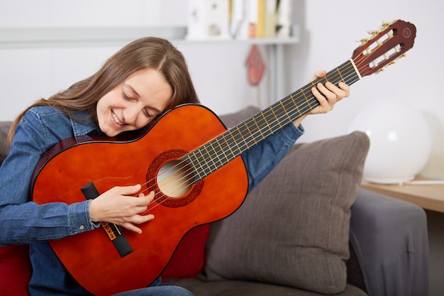 Vrouw speelt gitaar thuis