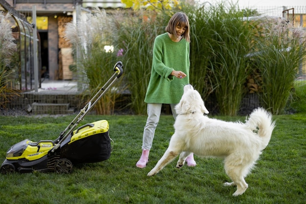 Vrouw speelt met haar hond in de achtertuin tijdens het tuinieren