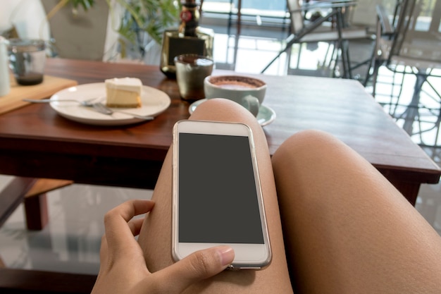 vrouw spelen smartphone in koffie winkel.