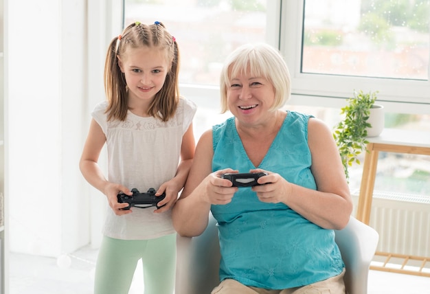 Vrouw spelen van videogame met kleindochter