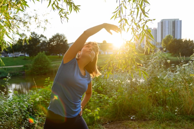 Vrouw sporten op het platteland bij zonsondergang