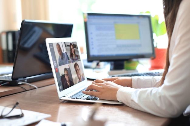 Vrouw spreekt tijdens videogesprek met collega's over online briefing tijdens zelfisolatie