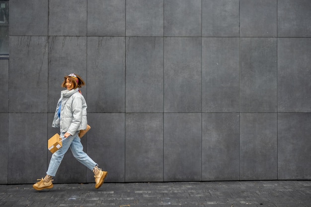 Vrouw springt terwijl ze buiten langs de muur loopt