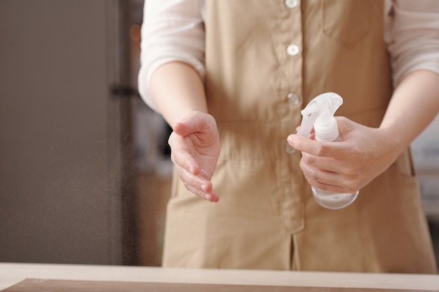 Vrouw sproeit water op handen