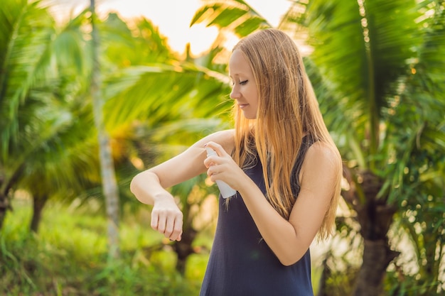 Vrouw spuiten insectenwerend middel op de huid buiten.