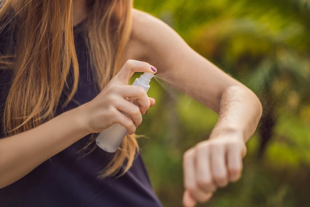 Vrouw spuiten insectenwerend middel op de huid buiten.