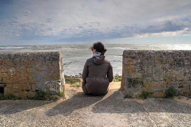 Foto vrouw staande op het strand tegen de lucht